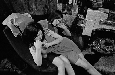 Sisters sharing a chair in a Gorbals slum tenement. Glasgow, 1970-thumb